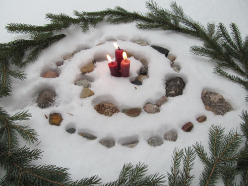 Ofrenda con piedras, velas y motivos vegetales para Yule en el solsticio de invierno